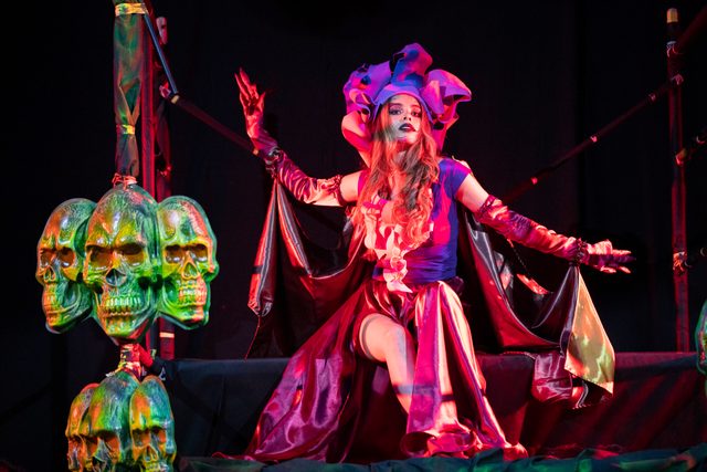 Actor con traje rojo y máscaras en una escena de fantasía