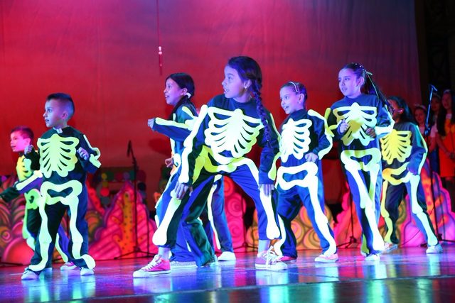 Bailarines con trajes de esqueleto que brillan en la oscuridad
