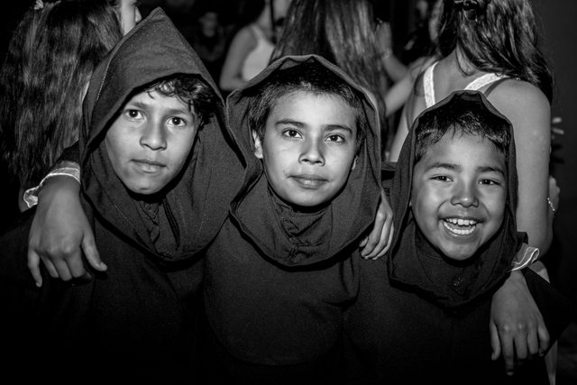 Retrato en blanco y negro de niños con capuchas, sonriendo