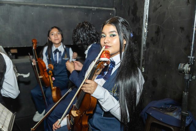 Jóvenes violinistas de la orquesta entre bastidores