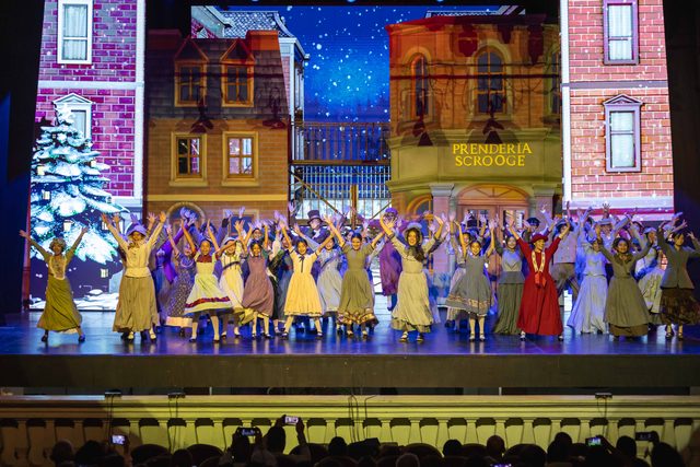 El elenco completo de Eleonora Scrooge frente a la escenografía nevada