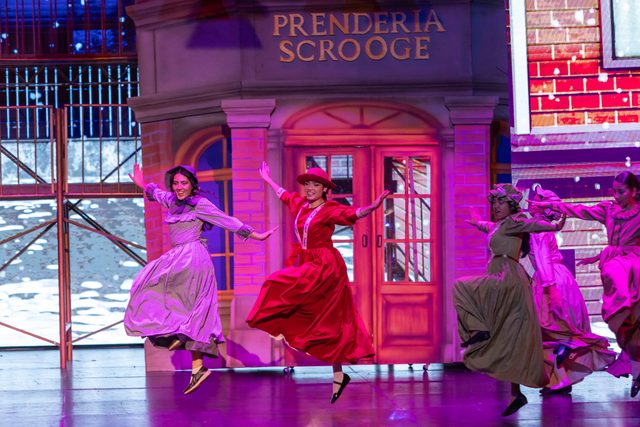 Jóvenes bailando en el musical Eleonora Scrooge frente a la Prendería Scrooge