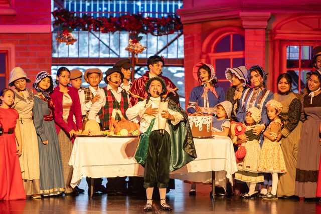 El elenco de Eleonora Scrooge alrededor de una mesa de banquete