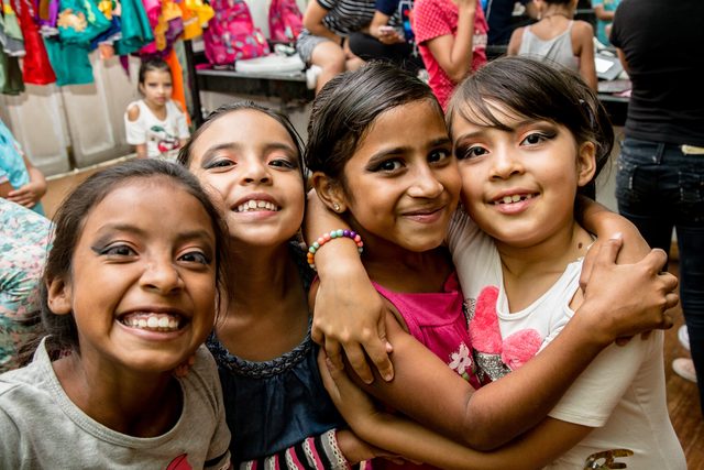 Niñas sonrientes abrazadas entre bastidores