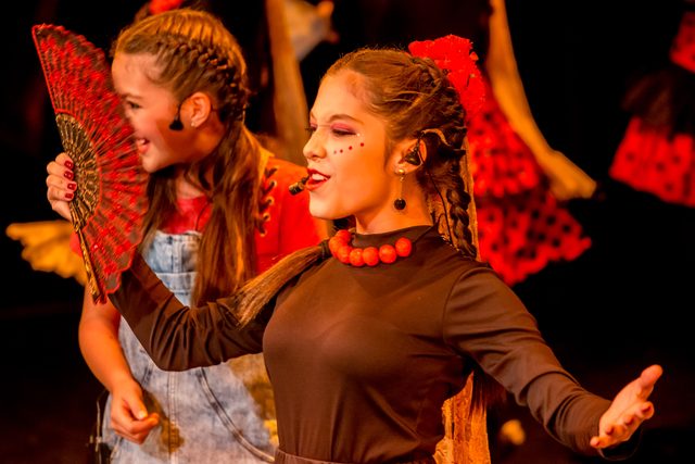 Dos niñas con trenzas y vestuario de colores