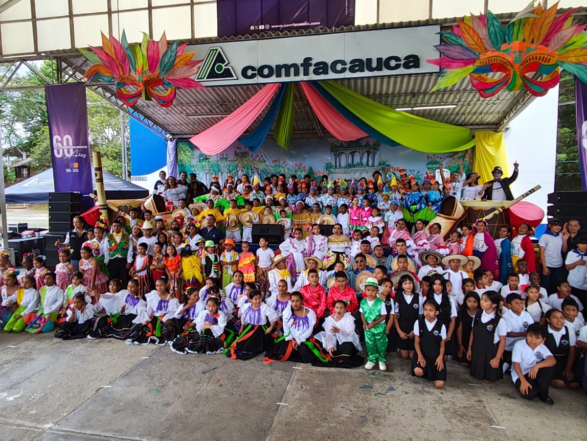 Group photo of the participants in front of the decorated Comfacauca stage