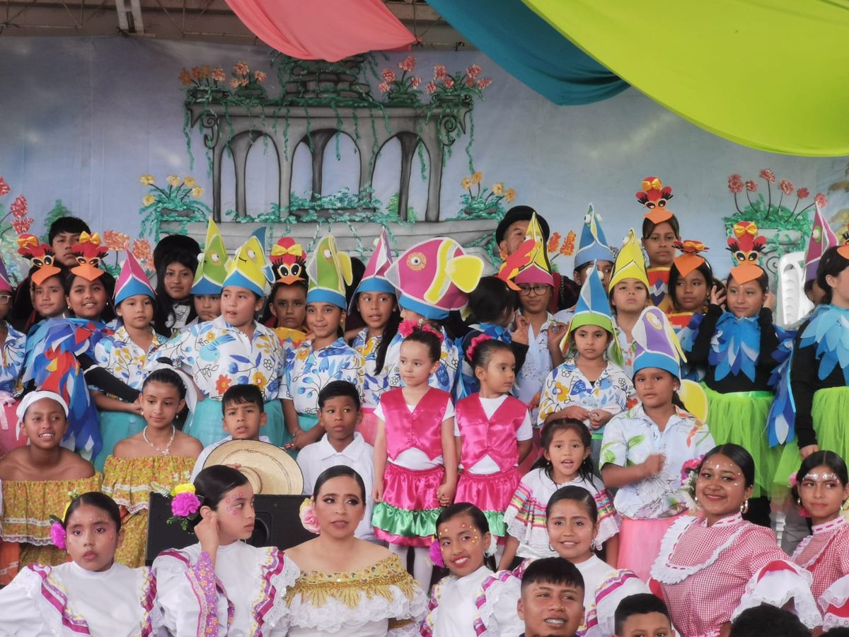 Children in colourful costumes in front of a painted backdrop