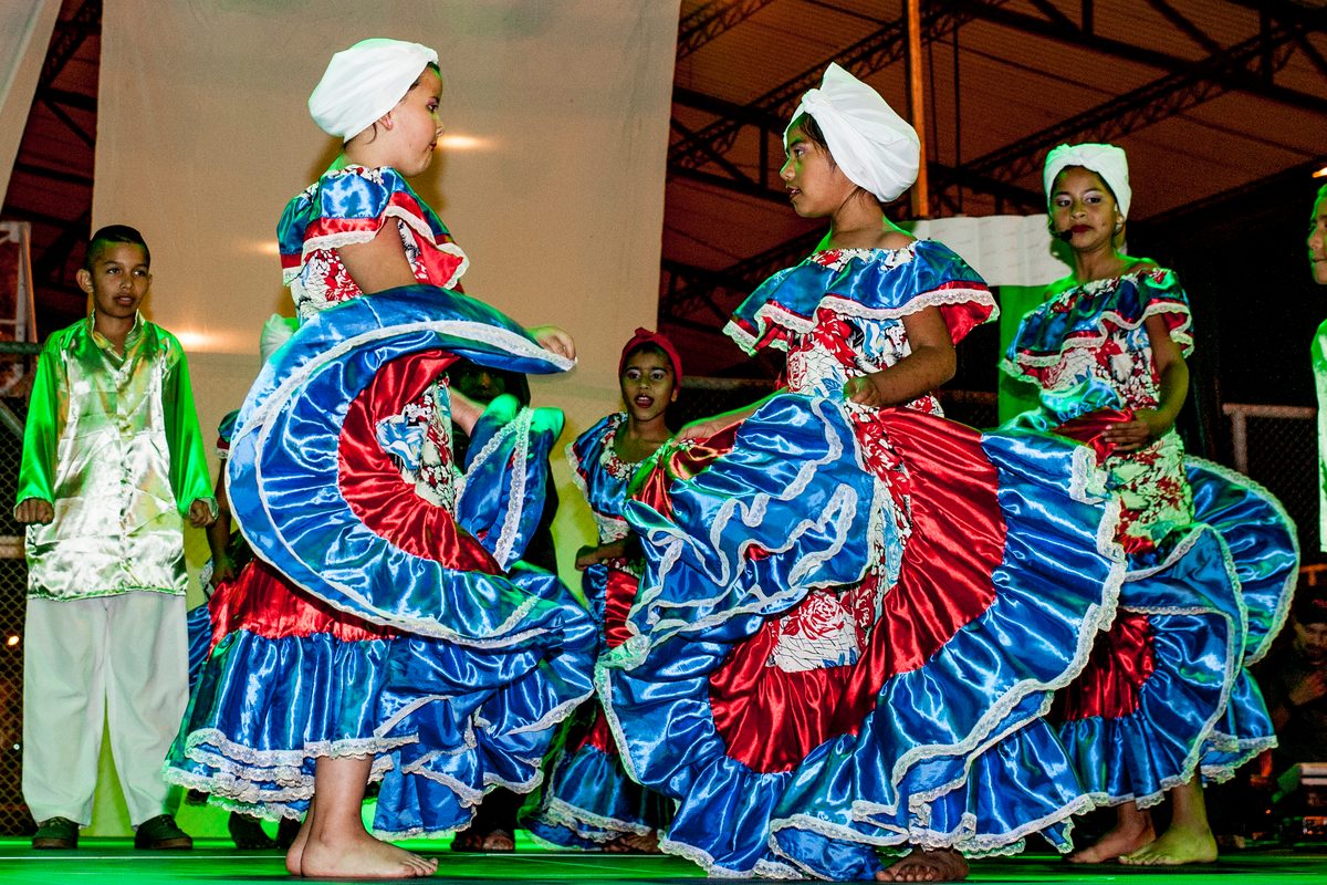 Bailarinas con faldas de colores giran en la tarima durante una muestra de Sonidos de la Convivencia