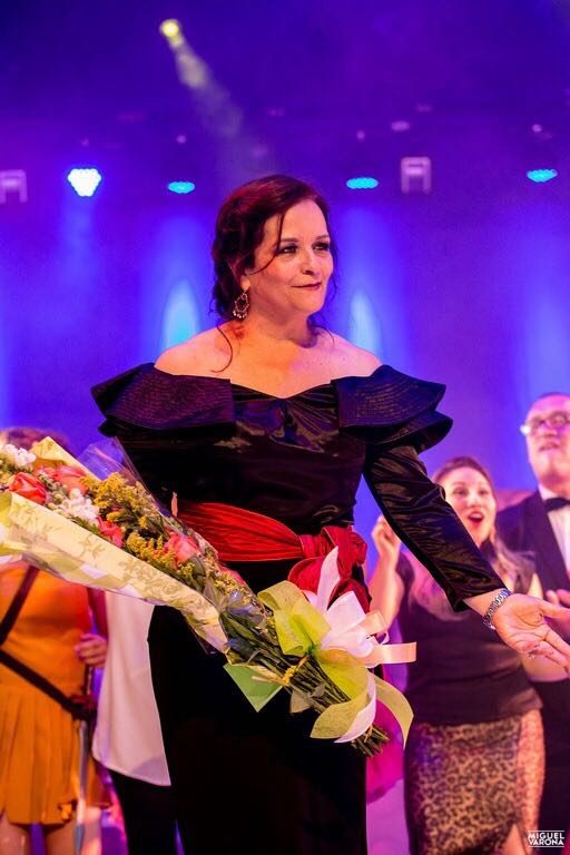Rosana receives flowers on stage after a show